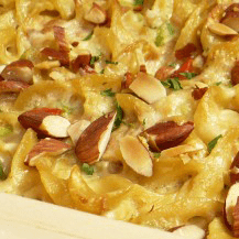 Close-up of baked macaroni and cheese topped with chopped almonds.