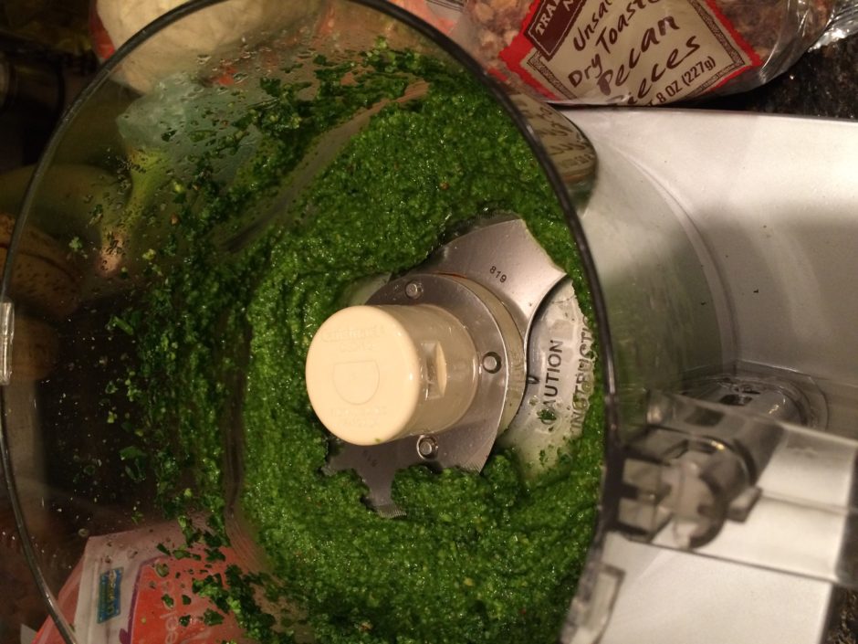 Blended green pesto sauce in a food processor bowl.