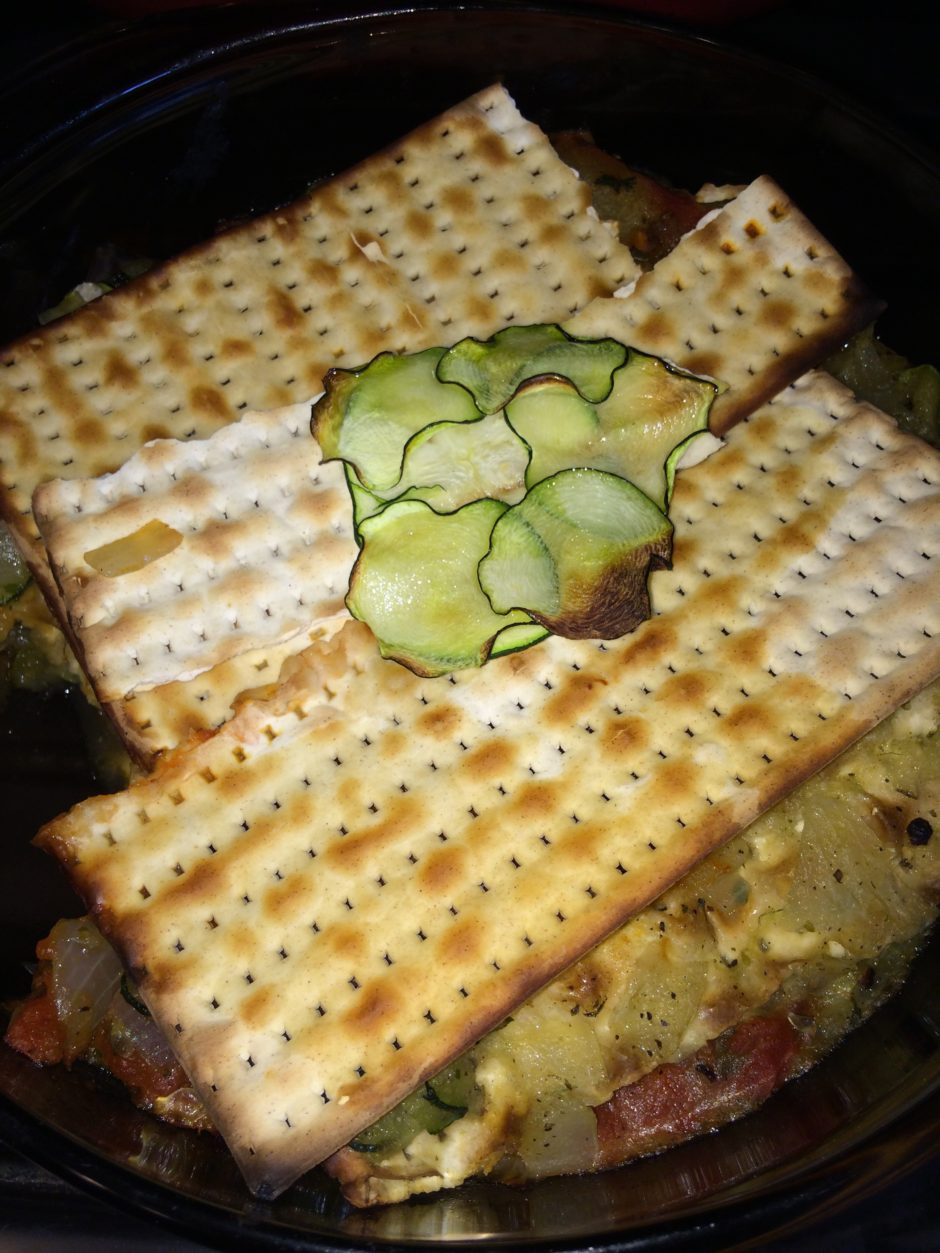 Matzo crackers topped with a spread and cucumber slices.