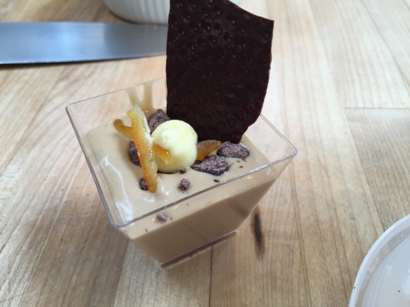 A chocolate mousse dessert topped with ice cream and a chocolate crisp.