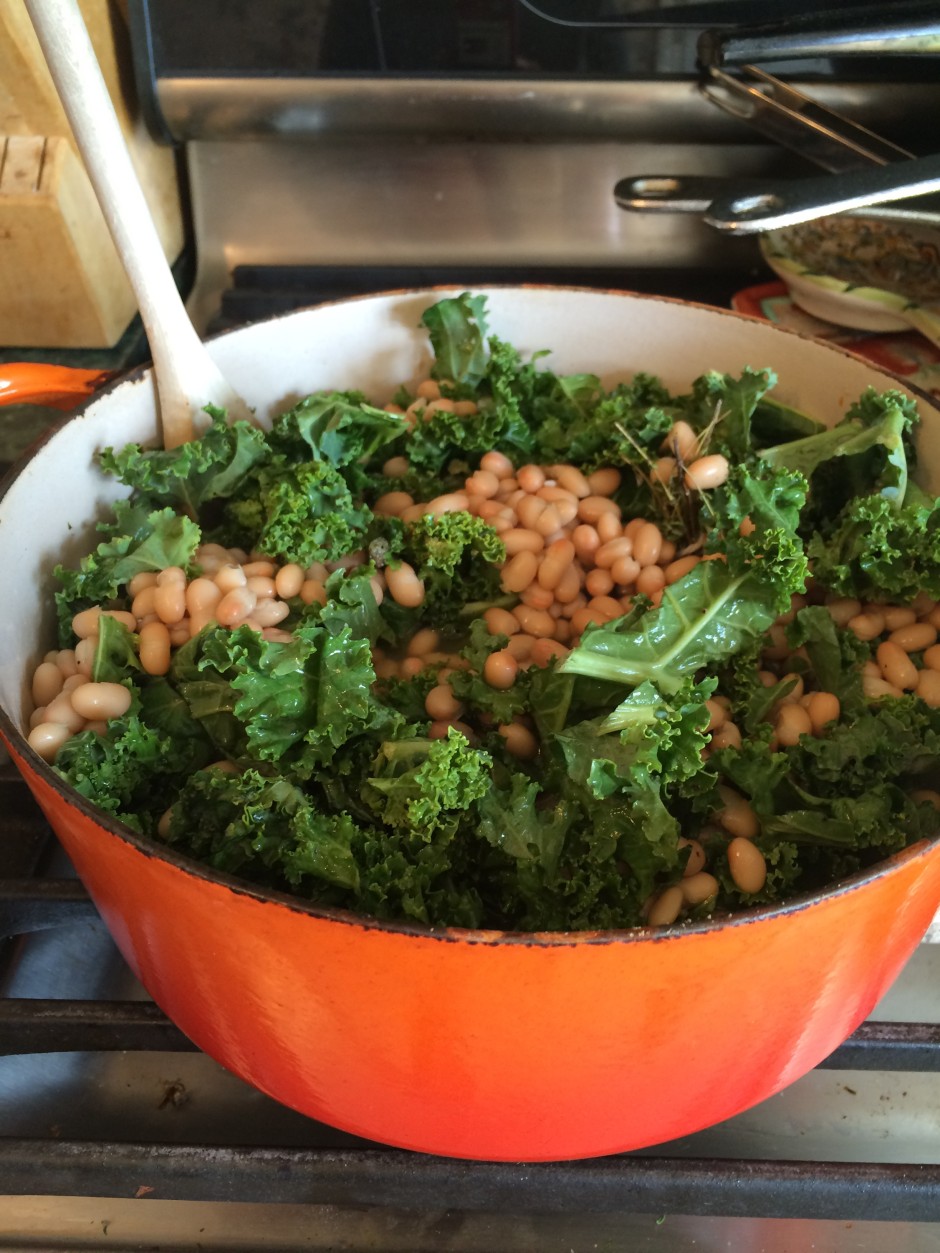 Bowl of chickpea salad with kale and dressing.