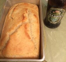 Bread loaf in pan with beer bottle.