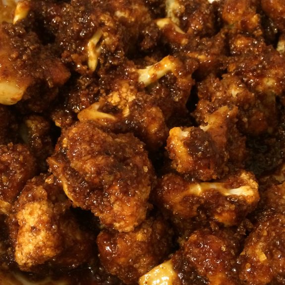 Close-up of spicy roasted cauliflower florets coated in seasoning.