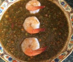 Shrimp-topped lentil soup served in a decorative bowl.