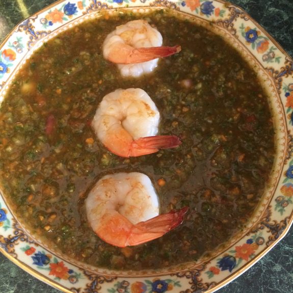 Shrimp-topped lentil soup served in a decorative bowl.