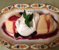 Dessert with cream, berries, and decorative plate.