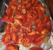 Roasted tomatoes on foil-lined baking tray.