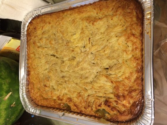 A golden-brown baked casserole in a foil tray.