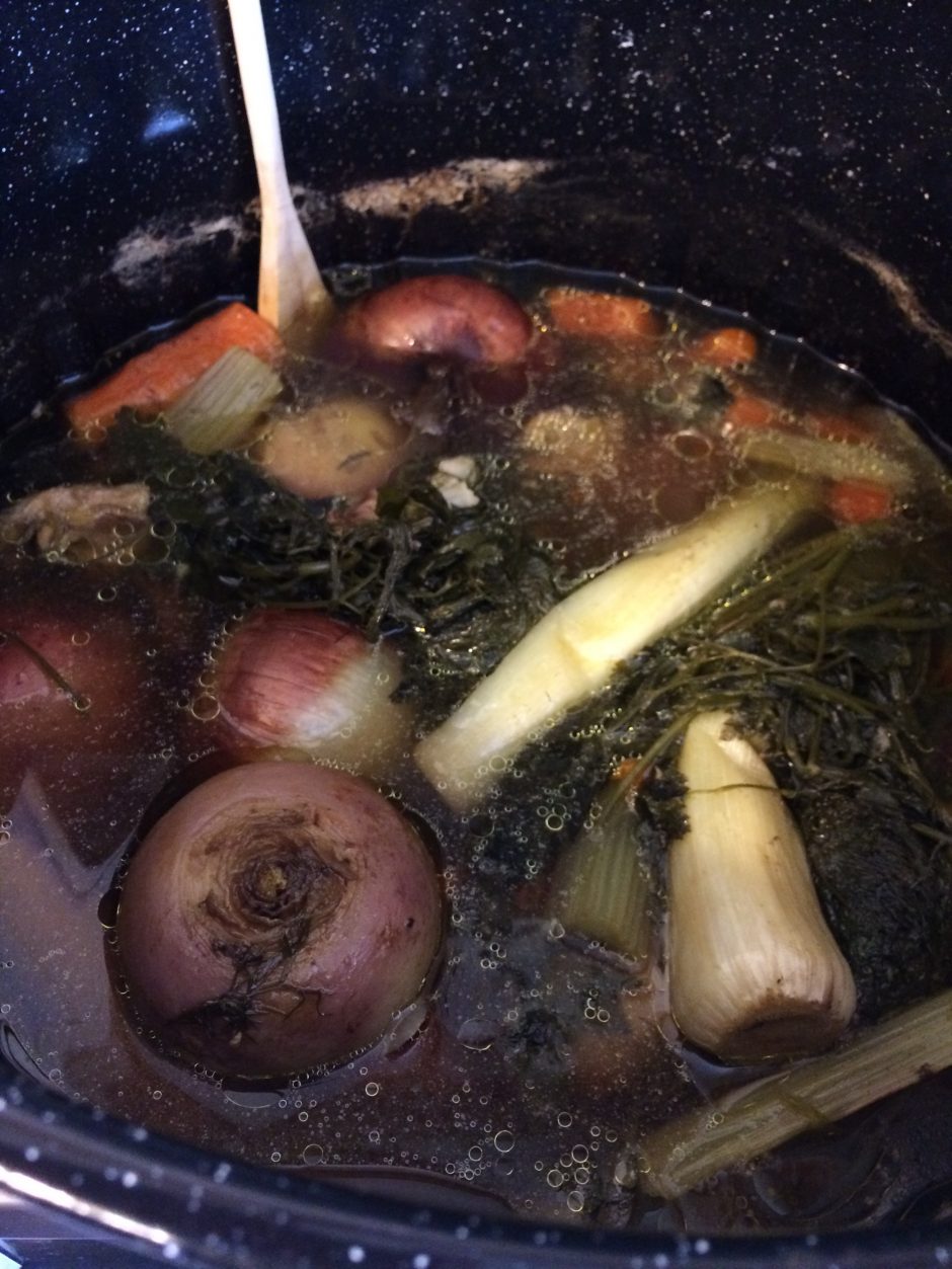 Vegetables simmering in a pot with herbs and garlic.