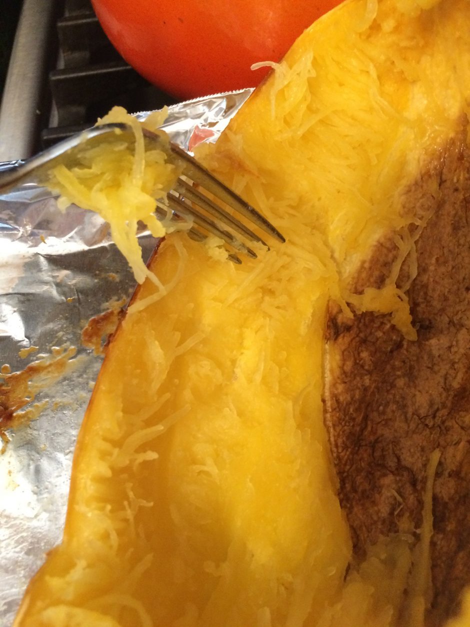 Close-up of a fork lifting melted cheese from a tortilla or quesadilla.
