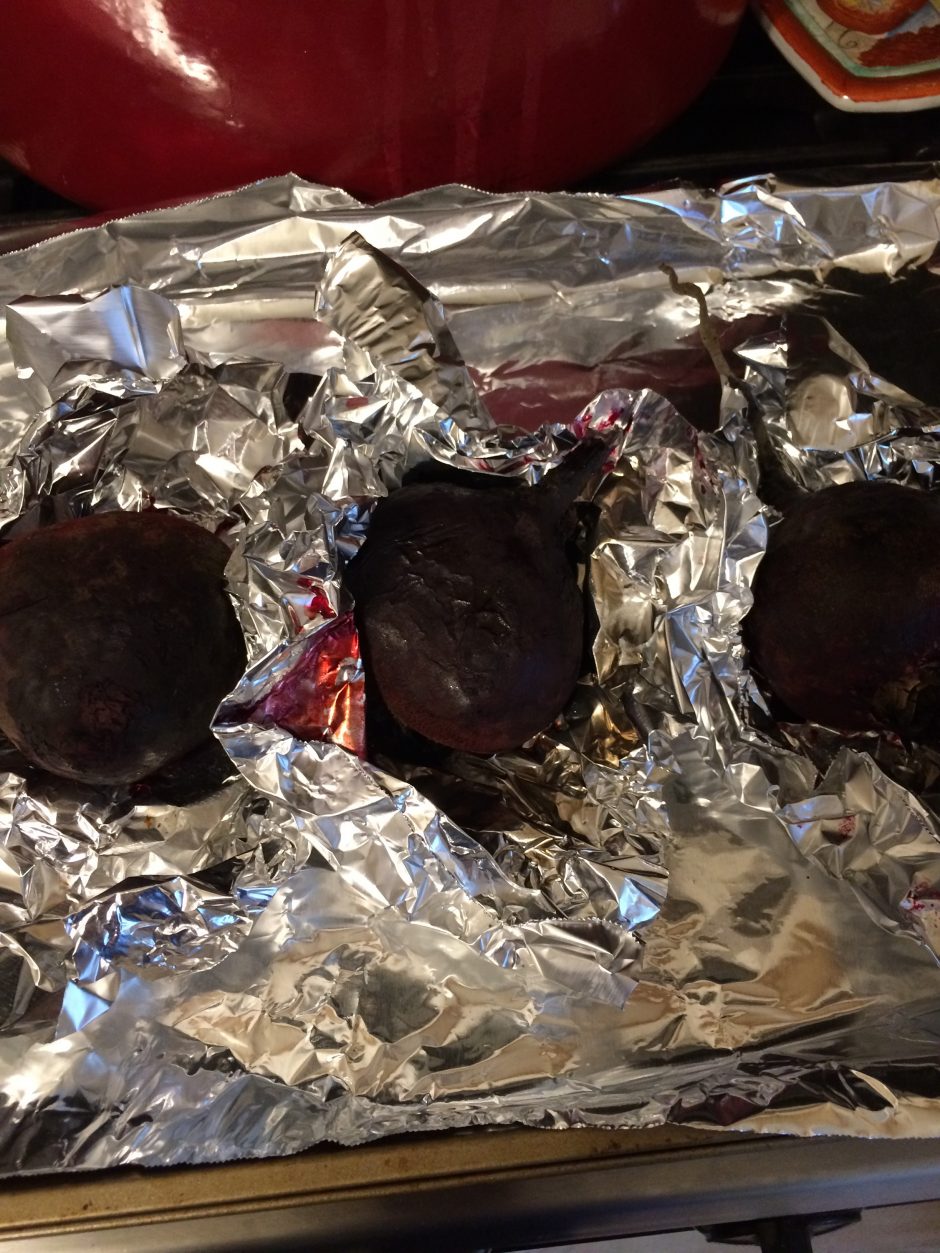 Three burnt cookies on aluminum foil.