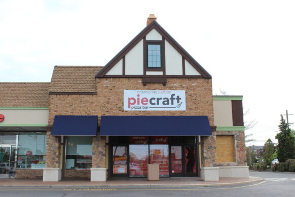 Brick building with "Piecraft" pizza bar sign.