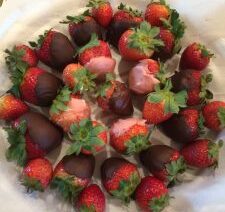 Chocolate and yogurt-covered strawberries on plate.
