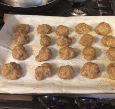 Meatballs on parchment-lined baking tray.