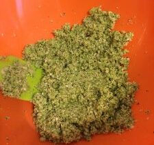 Green mixture in an orange mixing bowl.