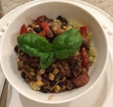 Bowl of mixed salad with basil leaves.