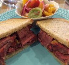 Sandwich with fruit salad on blue plate.