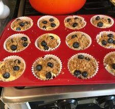 Blueberry muffins in a red baking tray.
