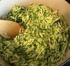 Shredded zucchini cooking in a pot.