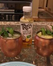 Copper mugs with drinks and TREO bottle.