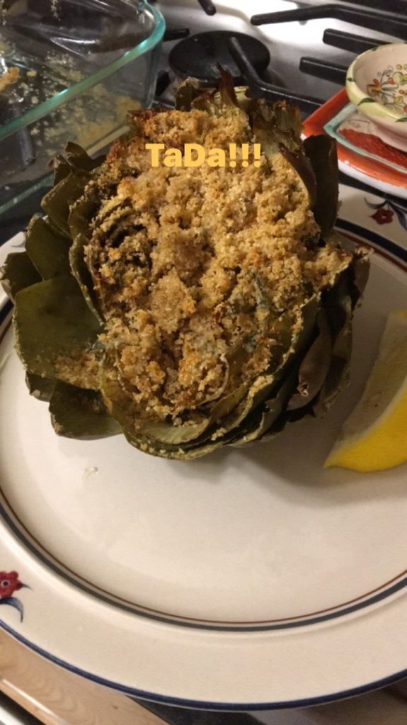 Close-up of fried artichoke on a plate with lemon wedge.