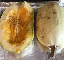 Halved spaghetti squash on foil-lined tray.