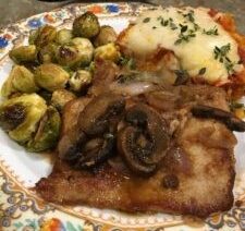 Dinner plate with meat, mushrooms, and vegetables.