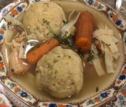 Matzo ball soup with carrots and noodles.