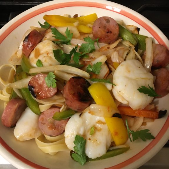 A colorful pasta dish with sausage and vegetables.