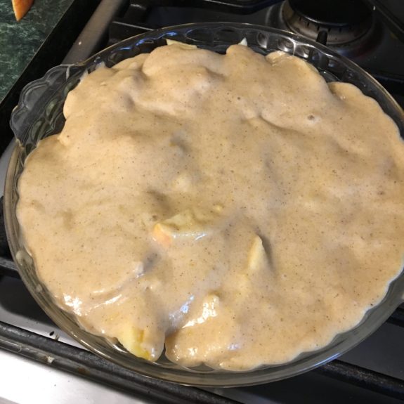 Unbaked pie with creamy filling on stovetop.