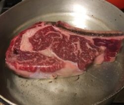 Raw steak in a frying pan.