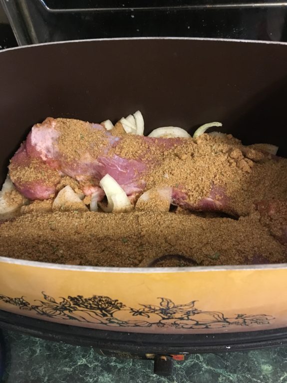 Cooked meat with onions in a casserole dish.