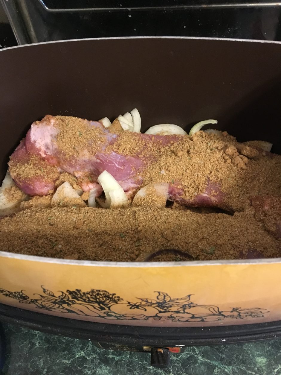 Cooked meat with onions in a casserole dish.