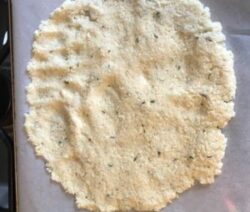 Cauliflower pizza crust on parchment paper.