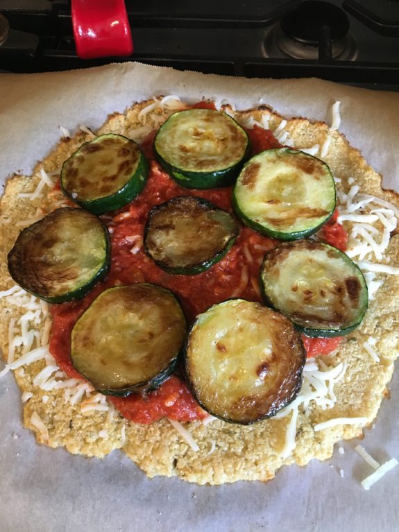 Uncooked vegetable tart with zucchini and tomato slices.