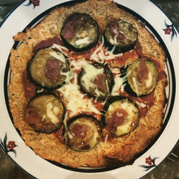 A homemade pizza topped with melted cheese and herbs.