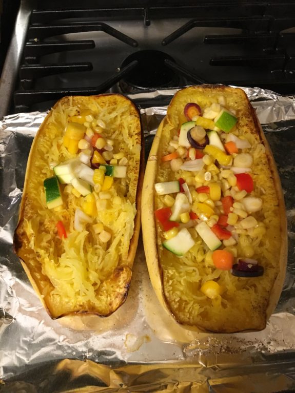 Two stuffed squash halves with colorful vegetable filling.