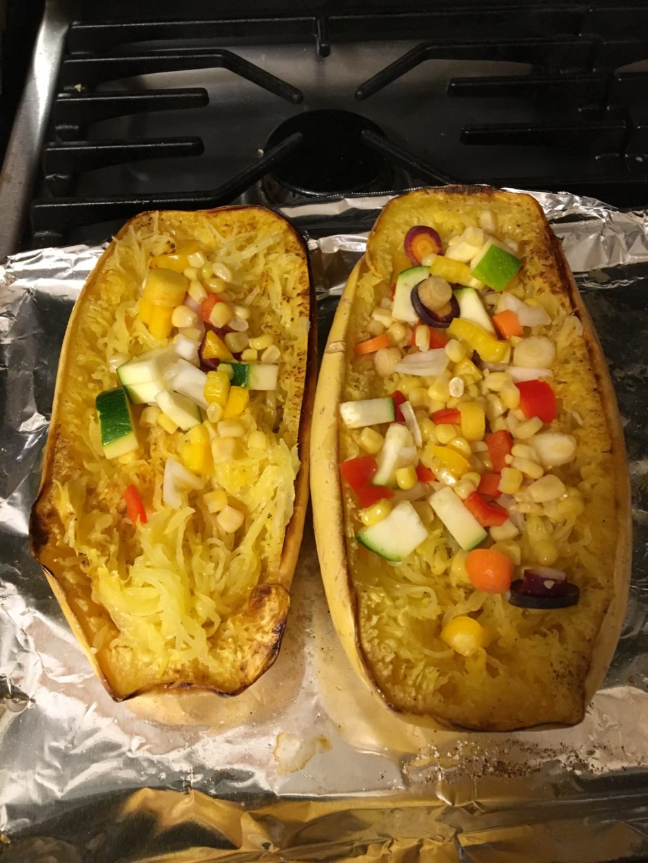 Two stuffed squash halves with colorful vegetable filling.