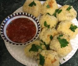 Breaded snacks with dipping sauce on plate.