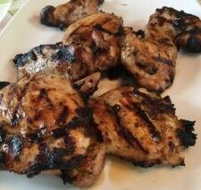 Grilled chicken pieces on a white plate.