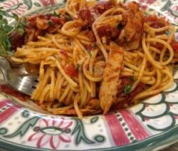 Spaghetti with tomato sauce on decorative plate.