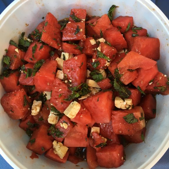 Fresh watermelon salad with mint and nuts in a bowl.
