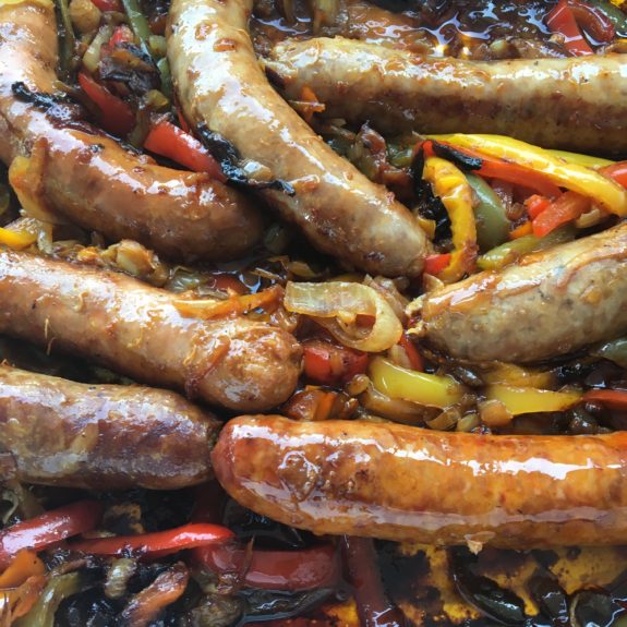 Grilled sausages with colorful bell peppers and onions.