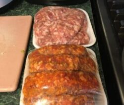 Packaged sausages and ground meat on counter.