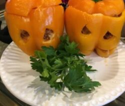 Stuffed peppers resembling jack-o'-lanterns on plate.