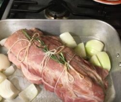 Raw roast with onions in baking pan.