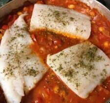 Fish fillets cooking in tomato sauce.