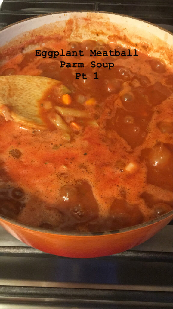 Close-up of a rich, bubbling tomato-based stew simmering in a pot.