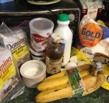 Baking ingredients and bananas on kitchen counter.