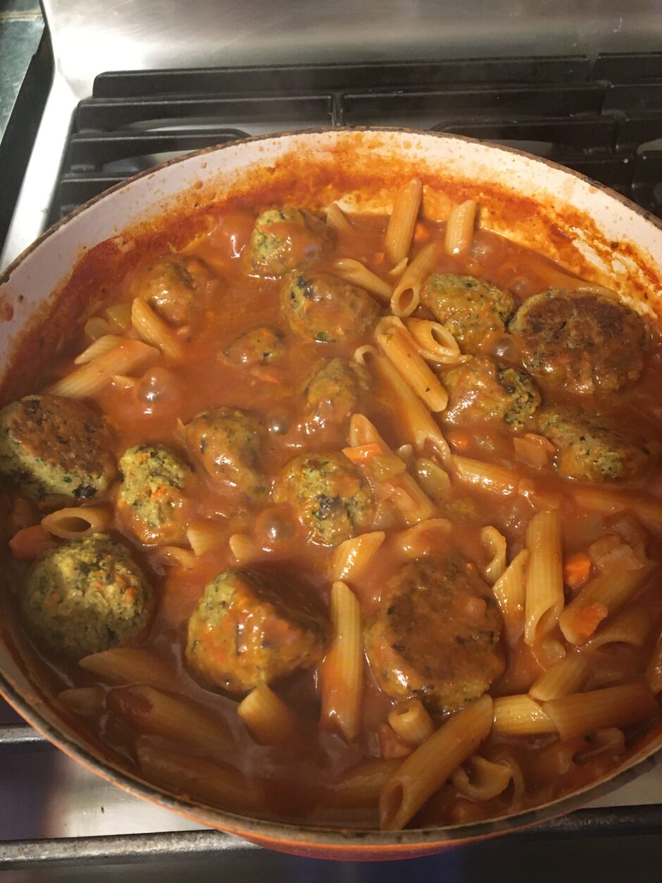Homemade meatballs in marinara sauce with pasta.
